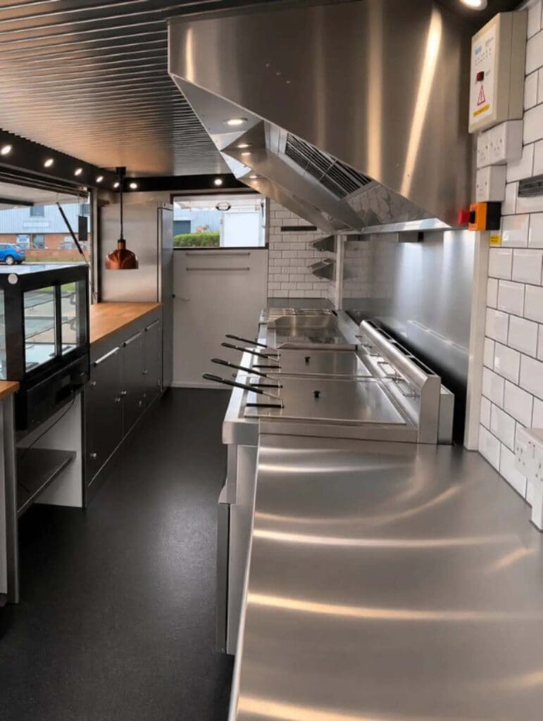 Fully equipped bespoke mobile catering trailer kitchen with stainless-steel extraction, commercial cooking equipment, refrigeration and oak worktops.